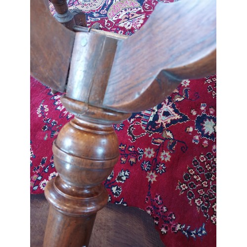 869 - A 19th century oak tripod table, the scalloped circular top upon a baluster column and three shaped ... 