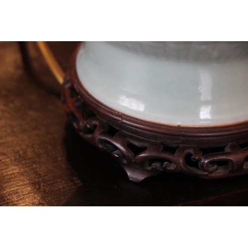 686 - A Chinese porcelain celadon lamp base, with all over scrolling leaf and vine decoration, hardwood ba... 