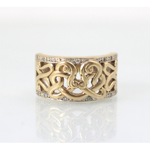 101 - A yellow metal dress ring, the openwork sinuous design to the centre of the ring leading to white st... 