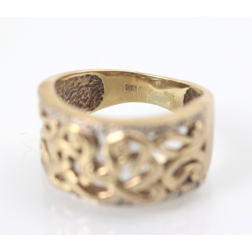 101 - A yellow metal dress ring, the openwork sinuous design to the centre of the ring leading to white st... 