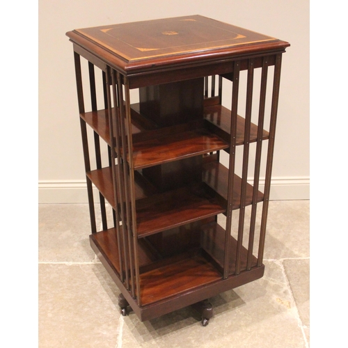 749 - An Edwardian mahogany revolving bookcase, the square top inlaid with a central satinwood batwing rou... 