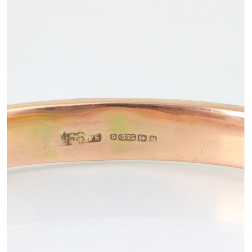 160 - A 9ct yellow gold bangle, the hollow bangle with engine turned detail to exterior, 8cm wide, 14gms