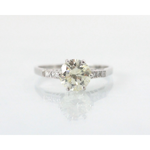 132 - A mid 20th century diamond solitaire ring, the central round cut diamond with a trio of diamonds set... 