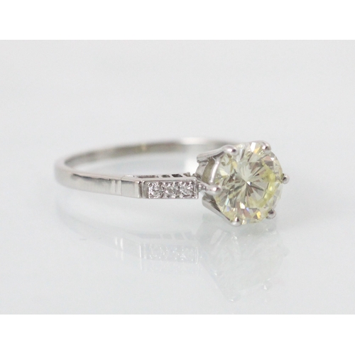 132 - A mid 20th century diamond solitaire ring, the central round cut diamond with a trio of diamonds set... 