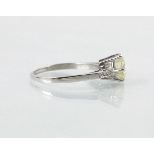 132 - A mid 20th century diamond solitaire ring, the central round cut diamond with a trio of diamonds set... 