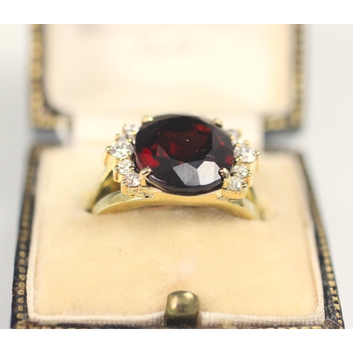 91 - A garnet and diamond dress ring, the oval cut garnet with five round cut diamonds to each side, with... 