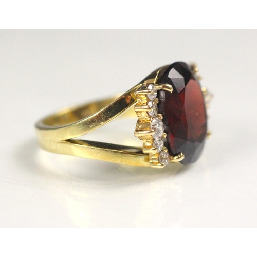 91 - A garnet and diamond dress ring, the oval cut garnet with five round cut diamonds to each side, with... 