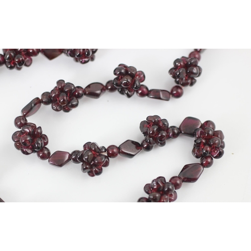 98 - A strand of untested garnet beads, the non-uniform polished beads with twenty-seven clusters of bead... 