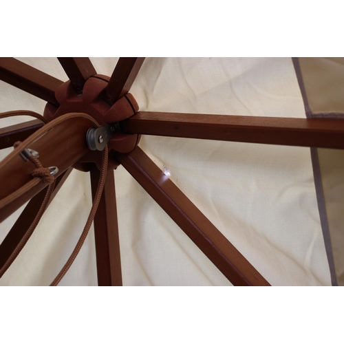 779 - A large garden/patio parasol, by Skagerak, Denmark, folding white fabric cover upon a hardwood pole ... 