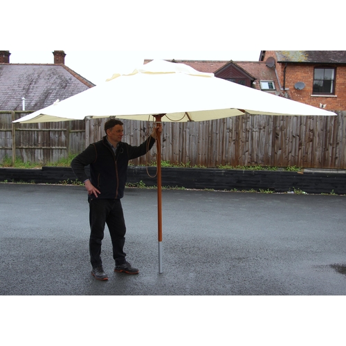 779 - A large garden/patio parasol, by Skagerak, Denmark, folding white fabric cover upon a hardwood pole ... 