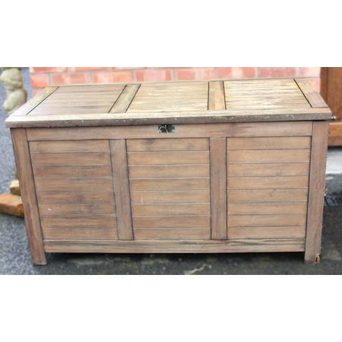 780 - An outdoor teak storage chest, of slatted form with a hinged cover and fitted side handles, upon sti... 