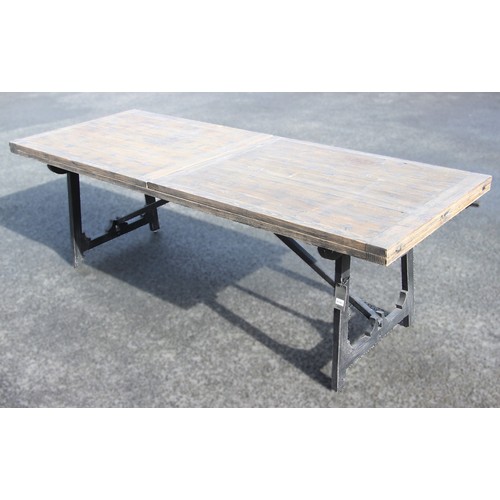 755 - An Oka 'Winglefield' trestle type folding dining table, the blackened pine extending slab top upon a... 