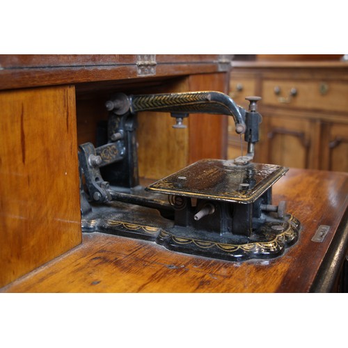 717 - A Victorian figured walnut davenport with integral Japanned 'The Roxburgh' sewing machine by Redpath... 