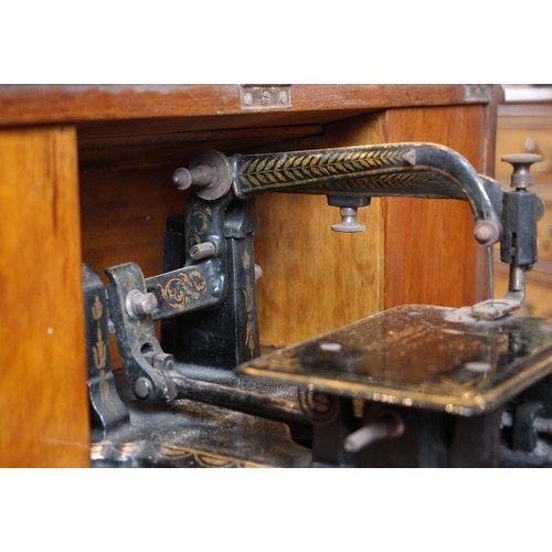 717 - A Victorian figured walnut davenport with integral Japanned 'The Roxburgh' sewing machine by Redpath... 