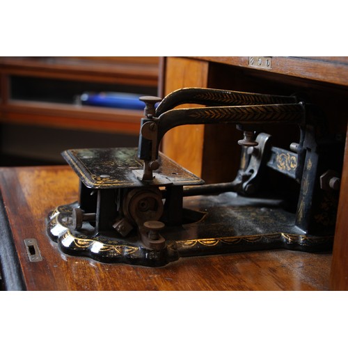 717 - A Victorian figured walnut davenport with integral Japanned 'The Roxburgh' sewing machine by Redpath... 