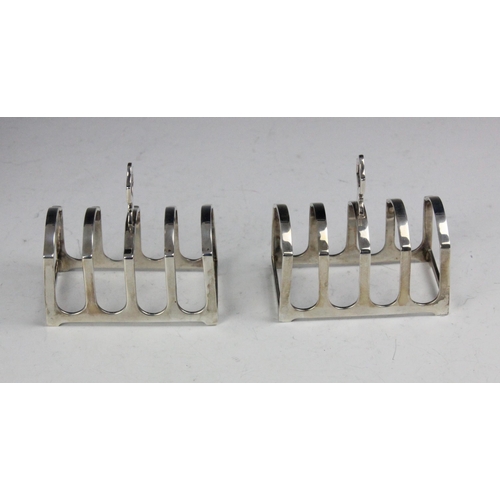 104 - A near pair of cased George V silver toast racks, Adie Brothers Ltd, Birmingham 1930/31, retailed by... 