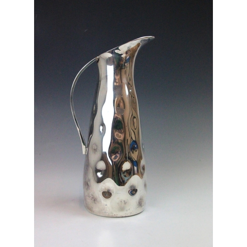 130 - A contemporary silver coloured jug, the planished tapered body with flared rim, 27.5cm high