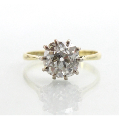 284 - A 20th century diamond solitaire ring, the old cut diamond with white metal claws leading to plain p... 