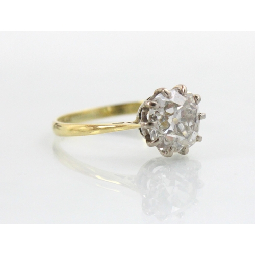 284 - A 20th century diamond solitaire ring, the old cut diamond with white metal claws leading to plain p... 