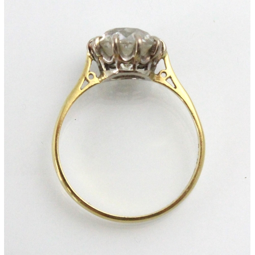 284 - A 20th century diamond solitaire ring, the old cut diamond with white metal claws leading to plain p... 