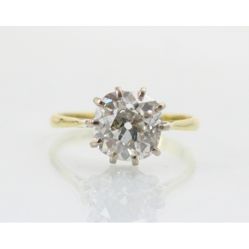 284 - A 20th century diamond solitaire ring, the old cut diamond with white metal claws leading to plain p... 