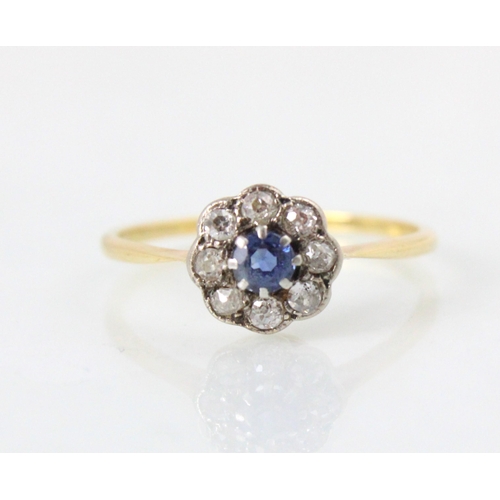 201 - An early 20th century untested sapphire and diamond cluster ring, the round cut blue stone within su... 