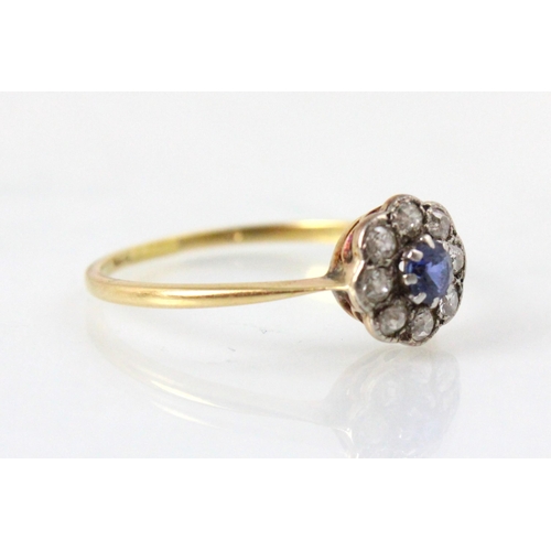 201 - An early 20th century untested sapphire and diamond cluster ring, the round cut blue stone within su... 