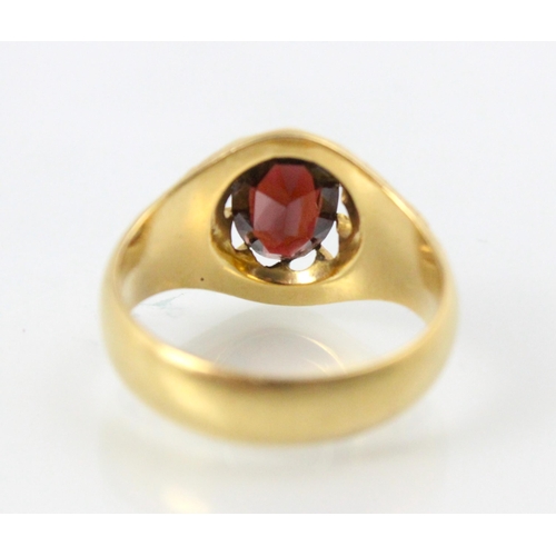 202 - An early 20th century 18ct yellow gold garnet ring, the oval cut garnet in openwork claw setting edg... 