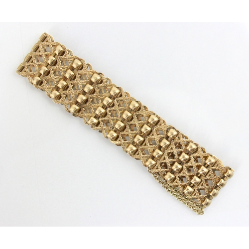 214 - A 9ct yellow gold panel style bracelet, the openwork bracelet with textured diamond shaped links wit... 