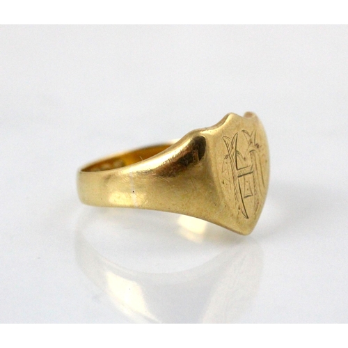 231 - An early 20th century 18ct yellow gold signet ring, the shield shaped head with engraved monogram, l... 