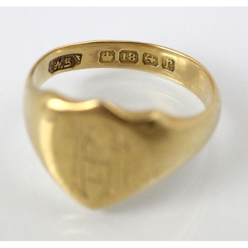 231 - An early 20th century 18ct yellow gold signet ring, the shield shaped head with engraved monogram, l... 