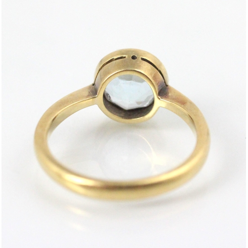 234 - An early 20th century untested aquamarine ring, the round cut untested aquamarine within yellow meta... 