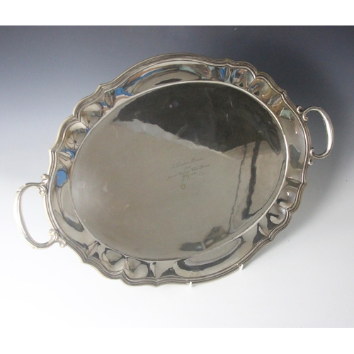 25 - An early 20th century continental white metal tray, the lobed rim with cast twin handles above oval ... 