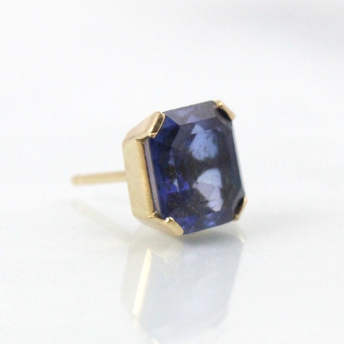 256 - A yellow metal mounted untested sapphire earring, the emerald cut stone within four claw setting, wi... 