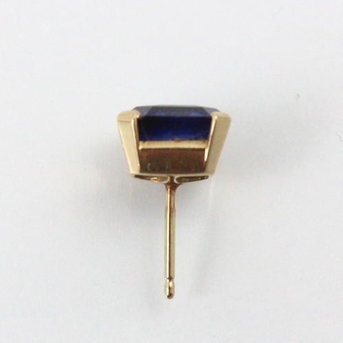 256 - A yellow metal mounted untested sapphire earring, the emerald cut stone within four claw setting, wi... 