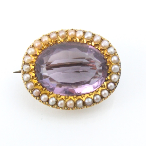 272 - An early 20th century untested amethyst and seed pearl set brooch, the oval cut stone within surroun... 