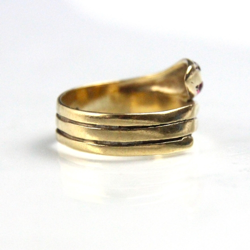 280 - A 9ct yellow gold and untested ruby serpent ring, the coiled snake with red stone set eyes, stamped ... 