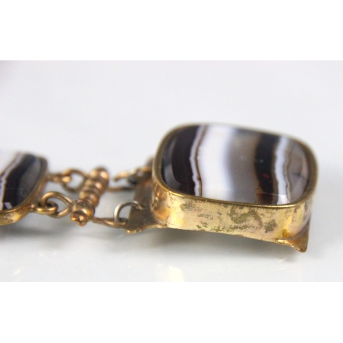 281 - A 19th century style banded agate panel bracelet, the four rounded rectangular panels within gold pl... 