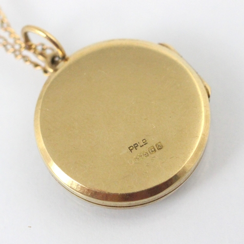 311 - A 9ct yellow gold pendant locket, the circular locket with engraved decoration to the front and plai... 