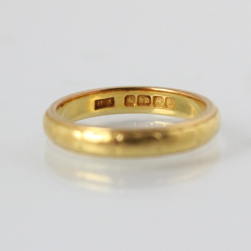 320 - An early 20th century 22ct yellow gold wedding band, with engraved decoration to exterior, stamped ‘... 