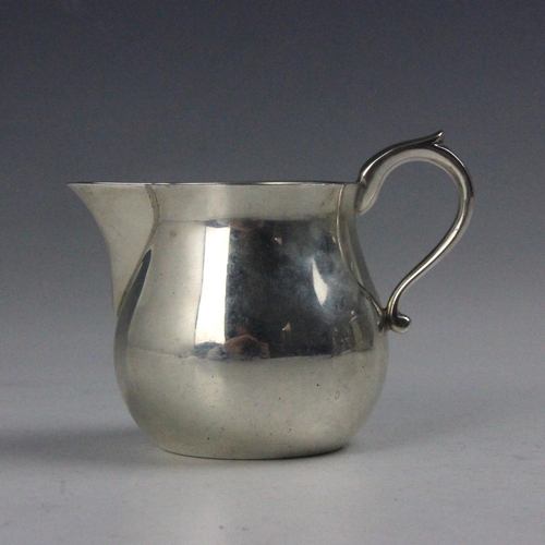 49 - A silver cream jug, Lowe and Sons, Chester 1961, the scroll handle above sparrows beaks and bulbous ... 