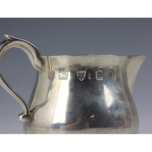 49 - A silver cream jug, Lowe and Sons, Chester 1961, the scroll handle above sparrows beaks and bulbous ... 