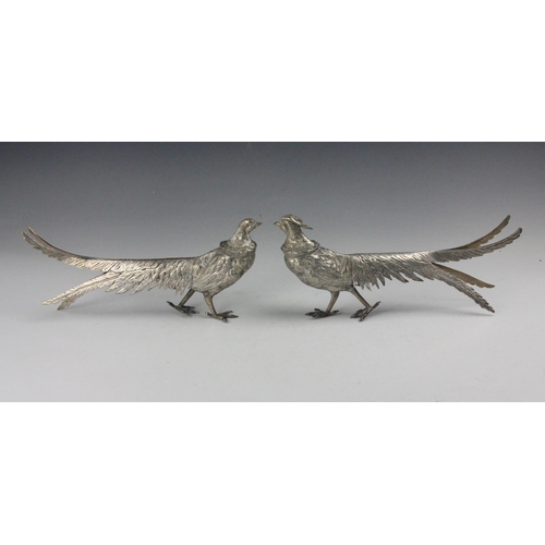 54 - A silver coloured model of a pheasant and hen pheasant, realistically modelled with chased detail, i... 