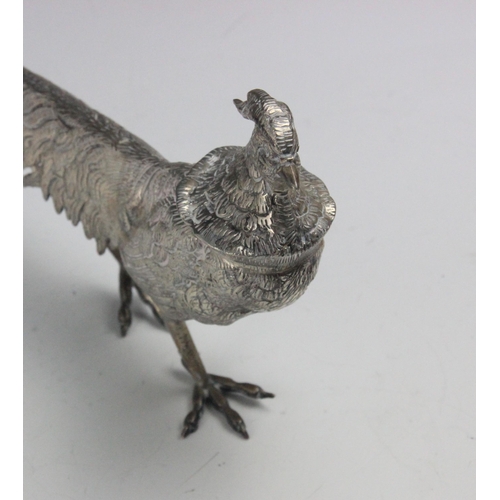 54 - A silver coloured model of a pheasant and hen pheasant, realistically modelled with chased detail, i... 