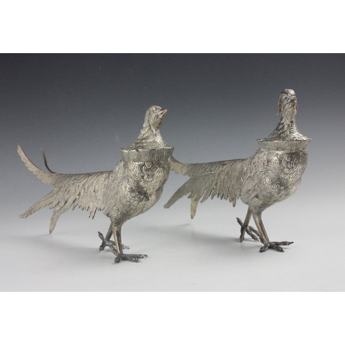 54 - A silver coloured model of a pheasant and hen pheasant, realistically modelled with chased detail, i... 