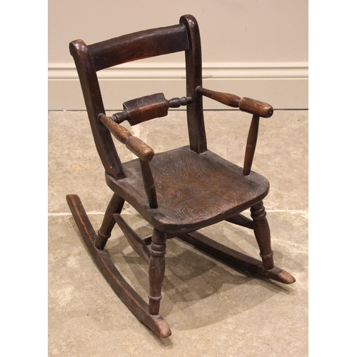 1011 - A Child’s elm and ash rocking chair, 19th century, the rail back above a shaped and figured seat, en... 