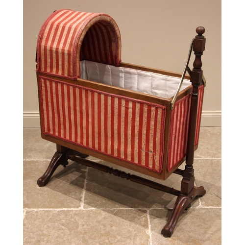 1014 - A Victorian mahogany framed cradle, in stripped fabric, the domed canopy over a lined interior, slat... 