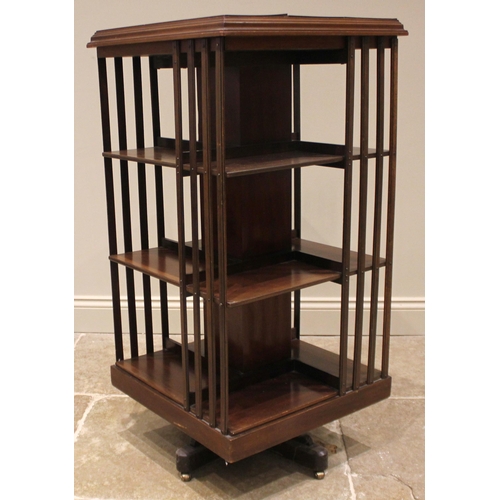 1018 - An Edwardian mahogany revolving bookcase, the moulded square top over three slatted open tiers, upon... 