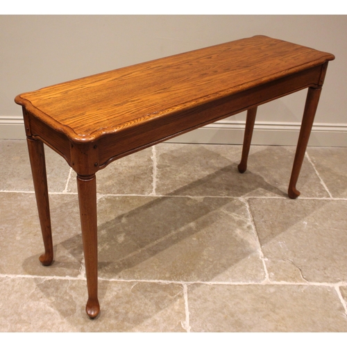 1053 - A Georgian style golden oak side table, late 20th century, the shaped and moulded top over a frieze ... 