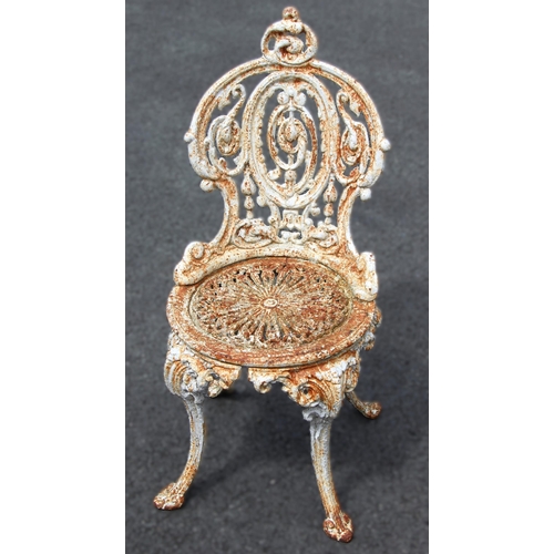 1089 - A Victorian painted cast iron garden or patio chair, with an oval openwork back rest, pierced circul... 